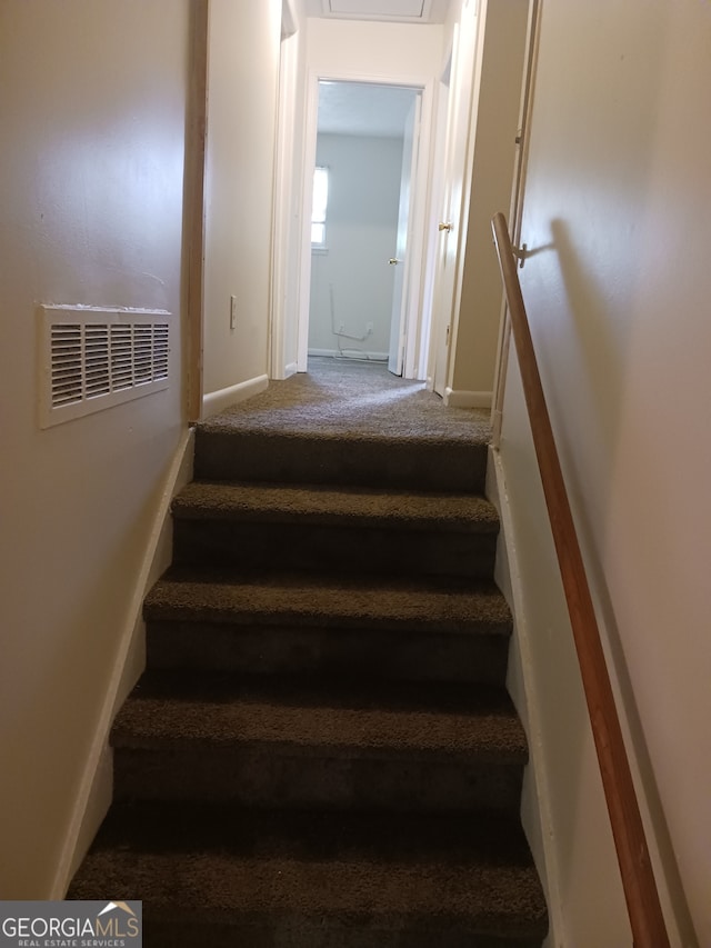 staircase featuring carpet flooring