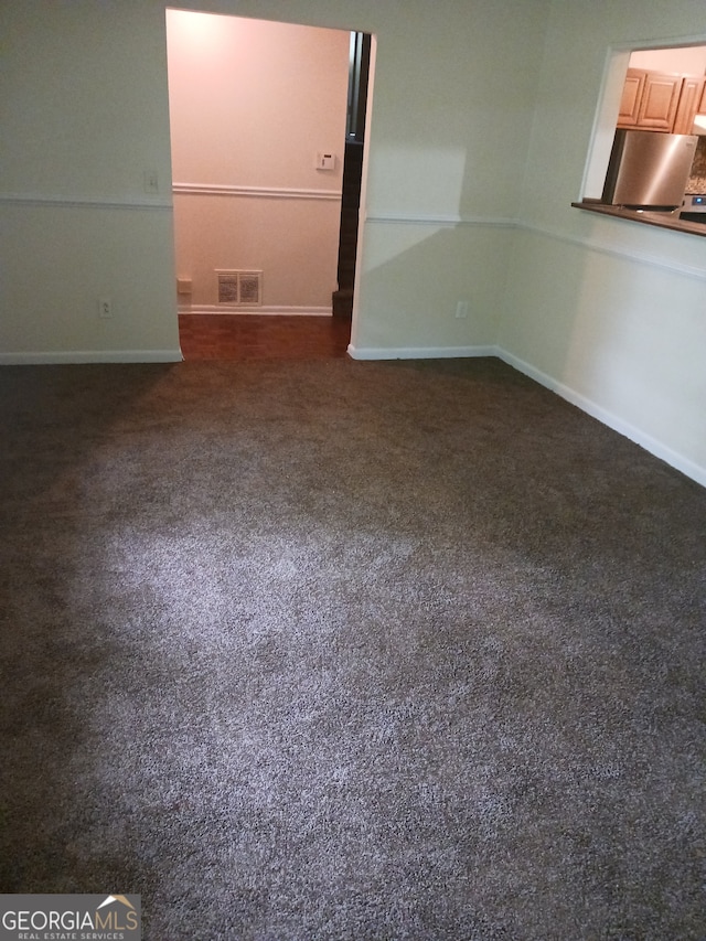 unfurnished bedroom featuring carpet floors and stainless steel fridge