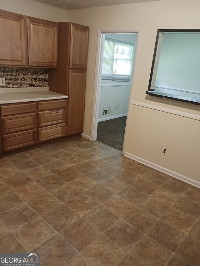 kitchen with dark tile patterned floors and backsplash