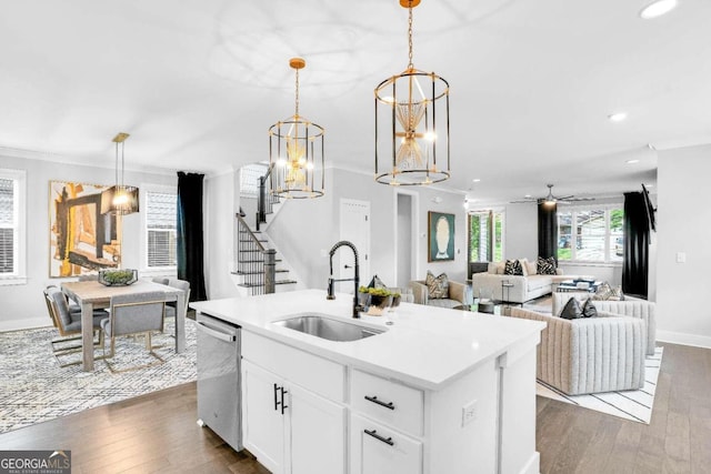 kitchen featuring a center island with sink, sink, dishwasher, dark hardwood / wood-style flooring, and ornamental molding