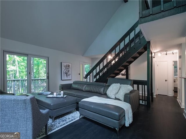 living room featuring dark wood-type flooring, vaulted ceiling, and a wealth of natural light