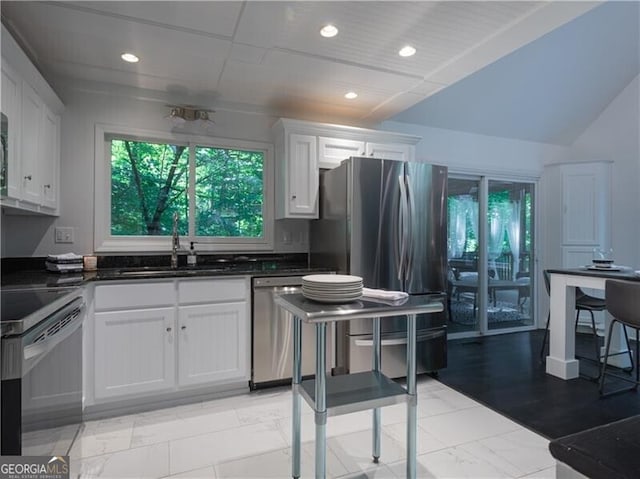 kitchen featuring sink, appliances with stainless steel finishes, white cabinets, and vaulted ceiling