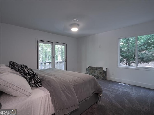 bedroom with dark carpet and access to outside