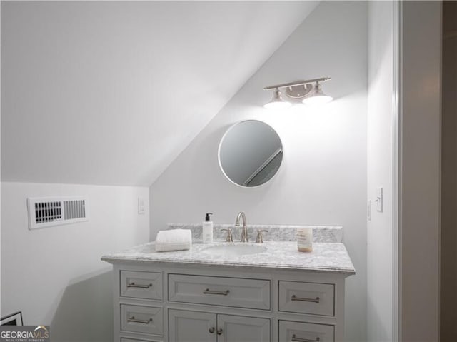 bathroom with vanity and vaulted ceiling