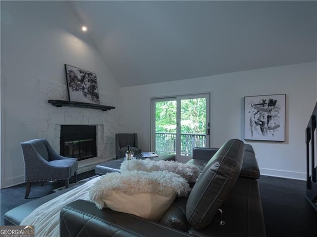 living room featuring high vaulted ceiling, dark hardwood / wood-style floors, and a stone fireplace