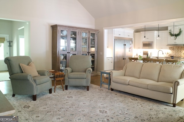 living room with light wood-style floors and high vaulted ceiling