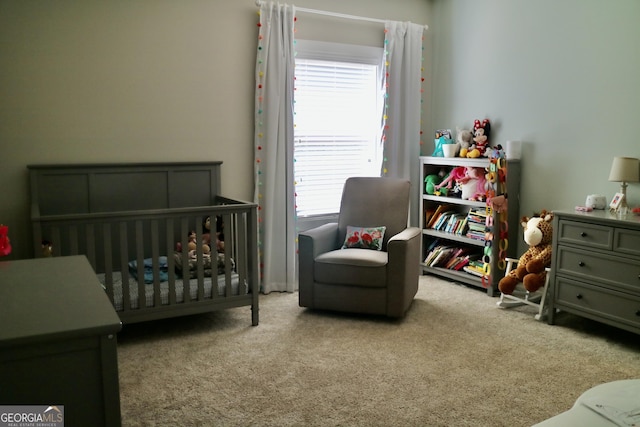 carpeted bedroom featuring a nursery area