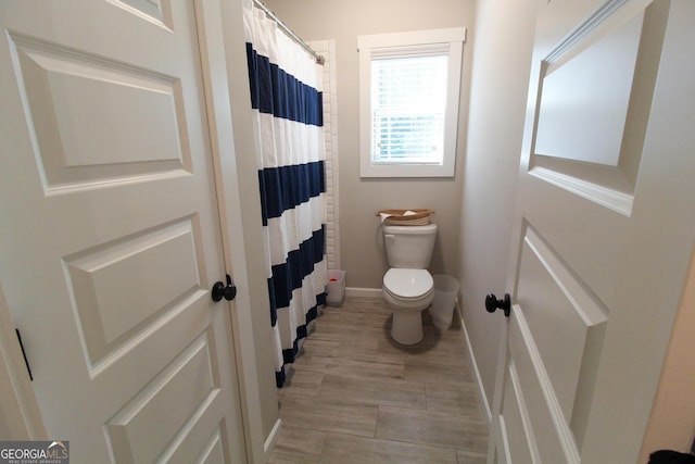 bathroom with toilet and baseboards