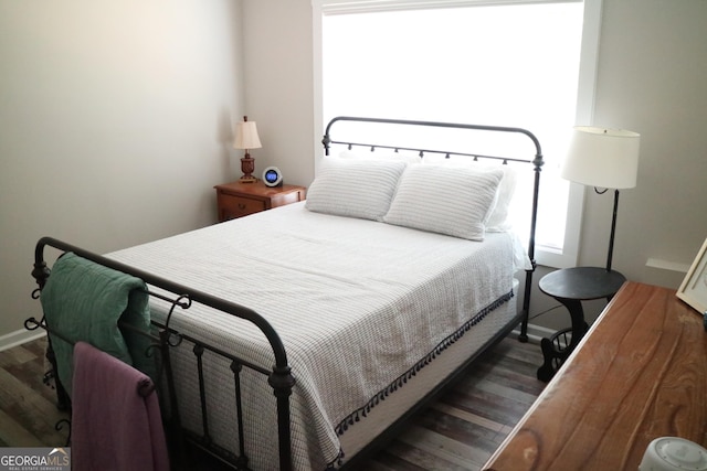 bedroom with dark wood-style floors and baseboards