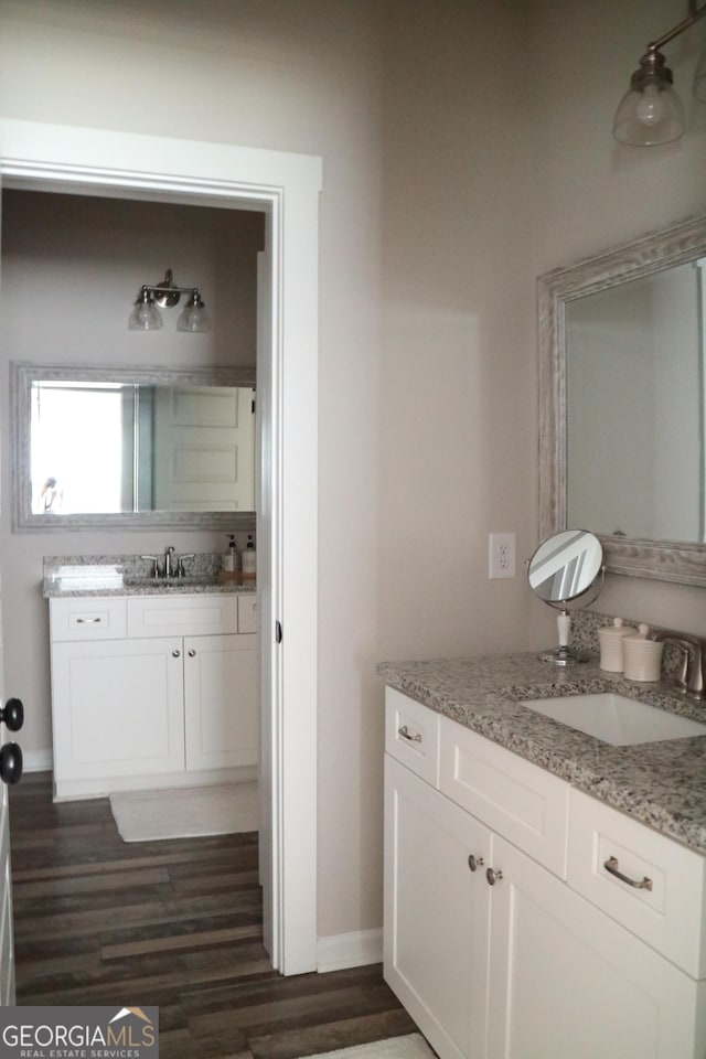 bathroom with vanity, baseboards, and wood finished floors