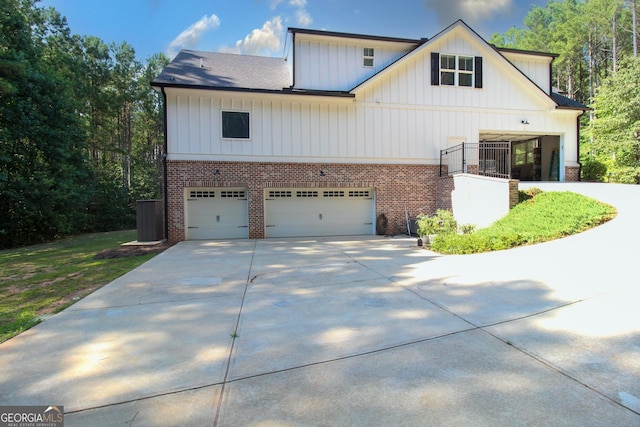 view of front of house with brick siding, roof with shingles, concrete driveway, an attached garage, and board and batten siding