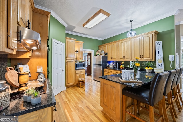 kitchen with a breakfast bar area, light wood finished floors, stainless steel appliances, ventilation hood, and a peninsula