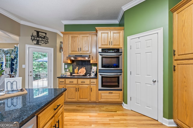 kitchen featuring crown molding, light wood finished floors, stainless steel double oven, and under cabinet range hood