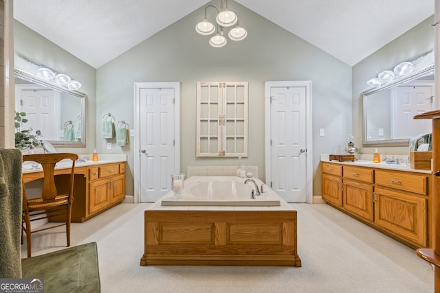 bathroom featuring lofted ceiling, vanity, and a bath