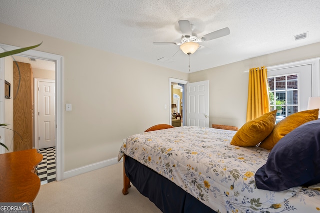 bedroom with carpet floors, visible vents, a textured ceiling, and baseboards