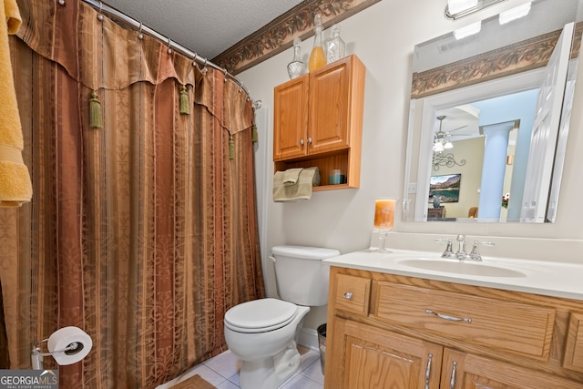 bathroom with toilet, vanity, a textured ceiling, and tile patterned floors