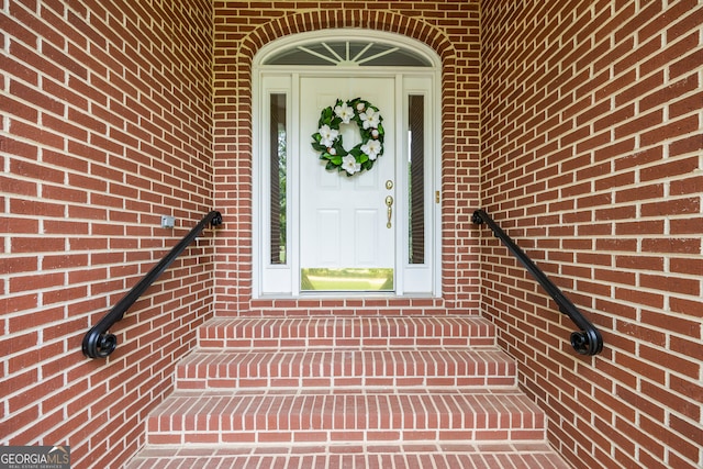 entrance to property featuring brick siding