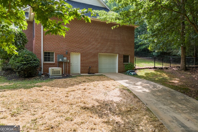 view of front of property featuring central AC unit, a garage, brick siding, fence, and driveway