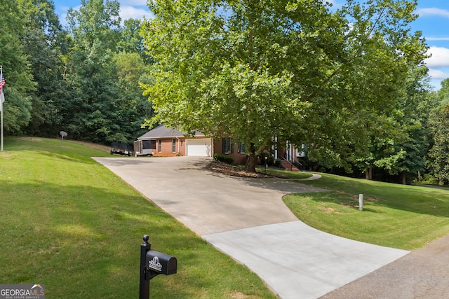 obstructed view of property with a garage, a front yard, and concrete driveway