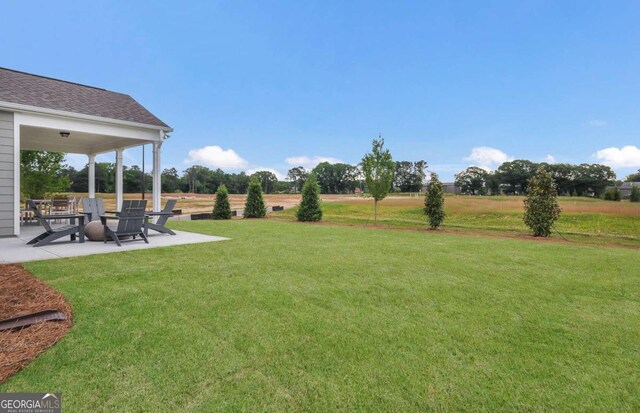 view of yard with a rural view and a patio