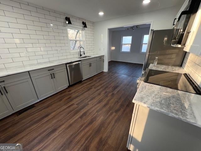 kitchen featuring sink, stainless steel dishwasher, light stone countertops, tasteful backsplash, and dark hardwood / wood-style flooring