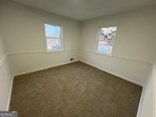 carpeted spare room featuring a healthy amount of sunlight