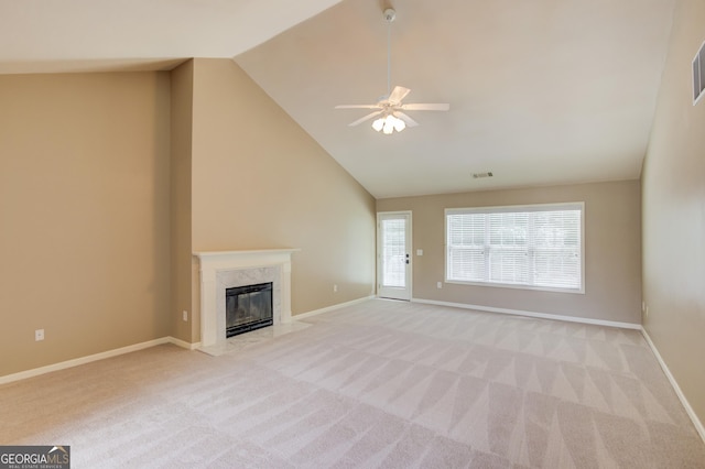 unfurnished living room with ceiling fan, lofted ceiling, light colored carpet, and a high end fireplace