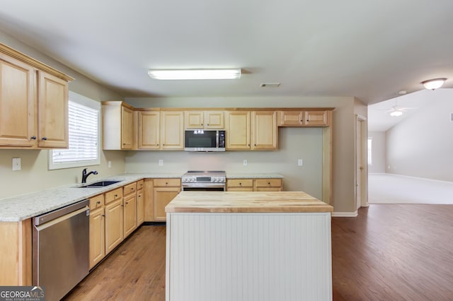 kitchen with sink, light hardwood / wood-style flooring, appliances with stainless steel finishes, butcher block counters, and light brown cabinets