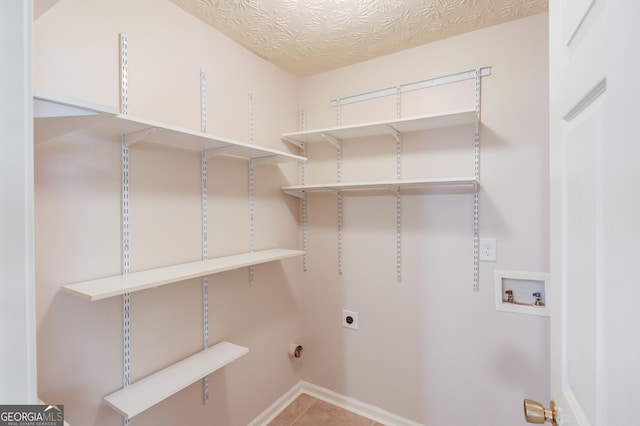 laundry room with washer hookup, tile patterned floors, hookup for an electric dryer, and a textured ceiling