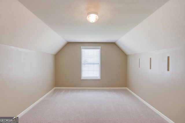 additional living space featuring lofted ceiling and carpet flooring