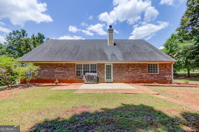 rear view of house featuring a patio and a lawn