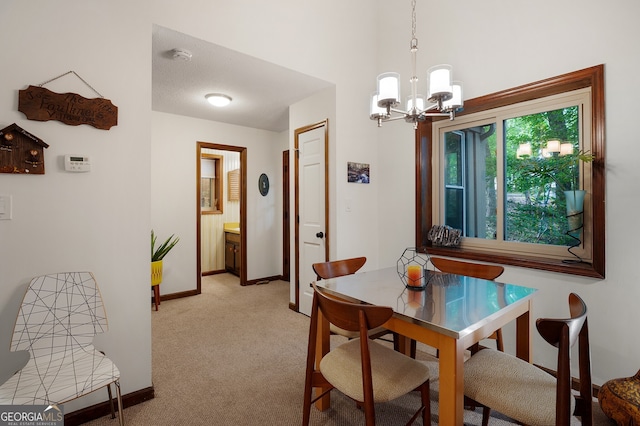 dining room with a chandelier and light carpet