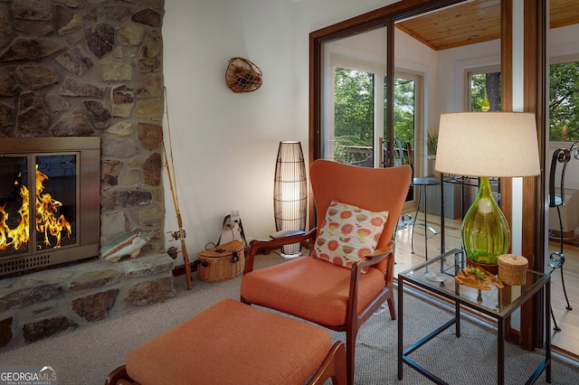 living room with carpet floors, wood ceiling, a fireplace, and lofted ceiling