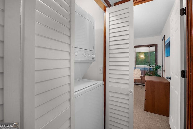 clothes washing area featuring stacked washer and clothes dryer and carpet floors