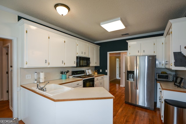 kitchen featuring visible vents, a sink, ornamental molding, a peninsula, and black appliances
