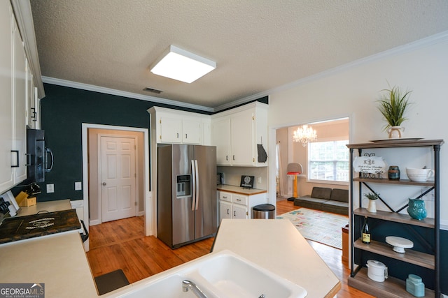 kitchen featuring a chandelier, crown molding, light wood finished floors, and stainless steel fridge