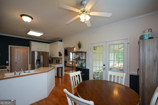 dining area with a ceiling fan, french doors, wood finished floors, and ornamental molding