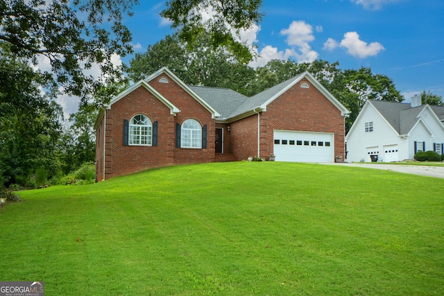 view of front of property with brick siding, a front lawn, an attached garage, and driveway
