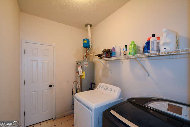 laundry area featuring laundry area, light floors, independent washer and dryer, a textured ceiling, and water heater