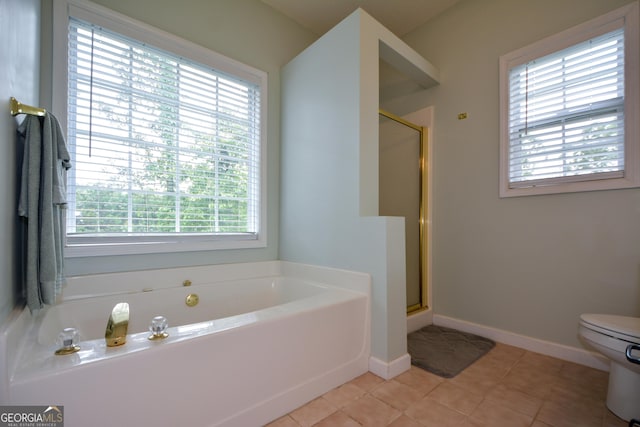 bathroom featuring a bath, a stall shower, baseboards, and toilet
