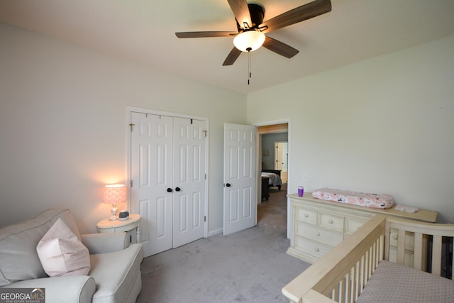 bedroom featuring a closet, light colored carpet, and a ceiling fan