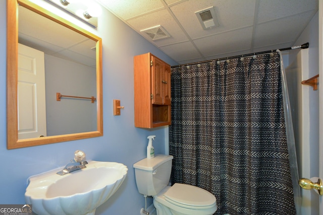 bathroom with a sink, visible vents, toilet, and a paneled ceiling