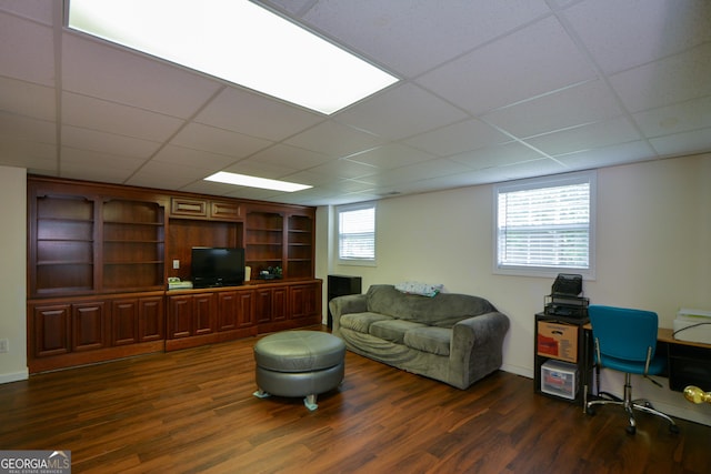 living room featuring a paneled ceiling and dark wood finished floors