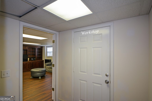 doorway to outside with a paneled ceiling and wood finished floors