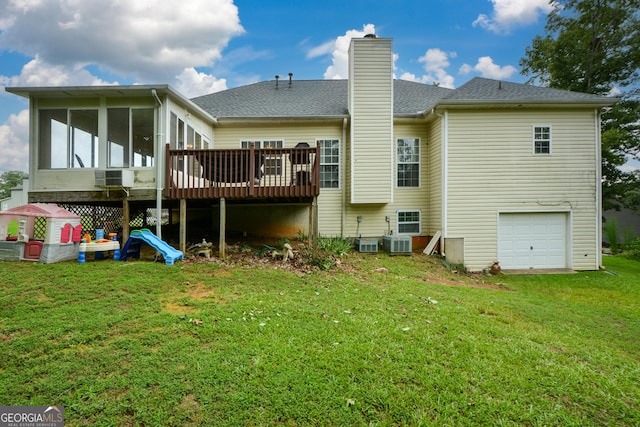 rear view of property featuring a chimney, a lawn, a garage, a sunroom, and a shingled roof