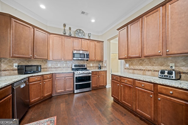 kitchen with appliances with stainless steel finishes, crown molding, tasteful backsplash, and dark hardwood / wood-style flooring