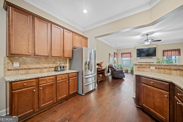 kitchen with stainless steel fridge, crown molding, dark wood-type flooring, and light stone counters