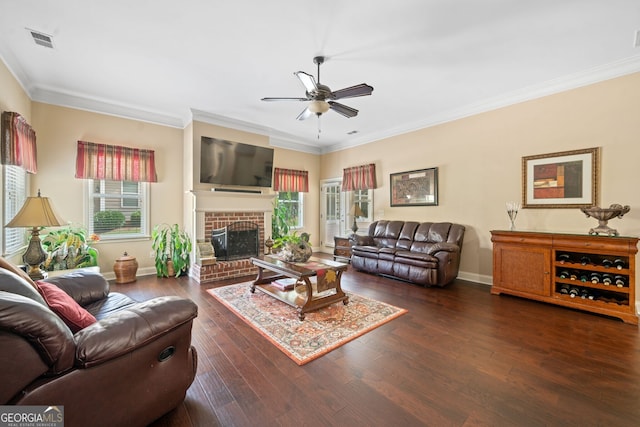 living room with a brick fireplace, ornamental molding, dark hardwood / wood-style flooring, and a healthy amount of sunlight