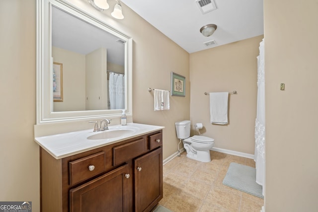 bathroom with vanity, tile patterned flooring, and toilet