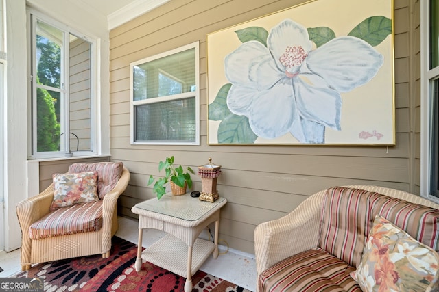 sitting room featuring crown molding and wooden walls